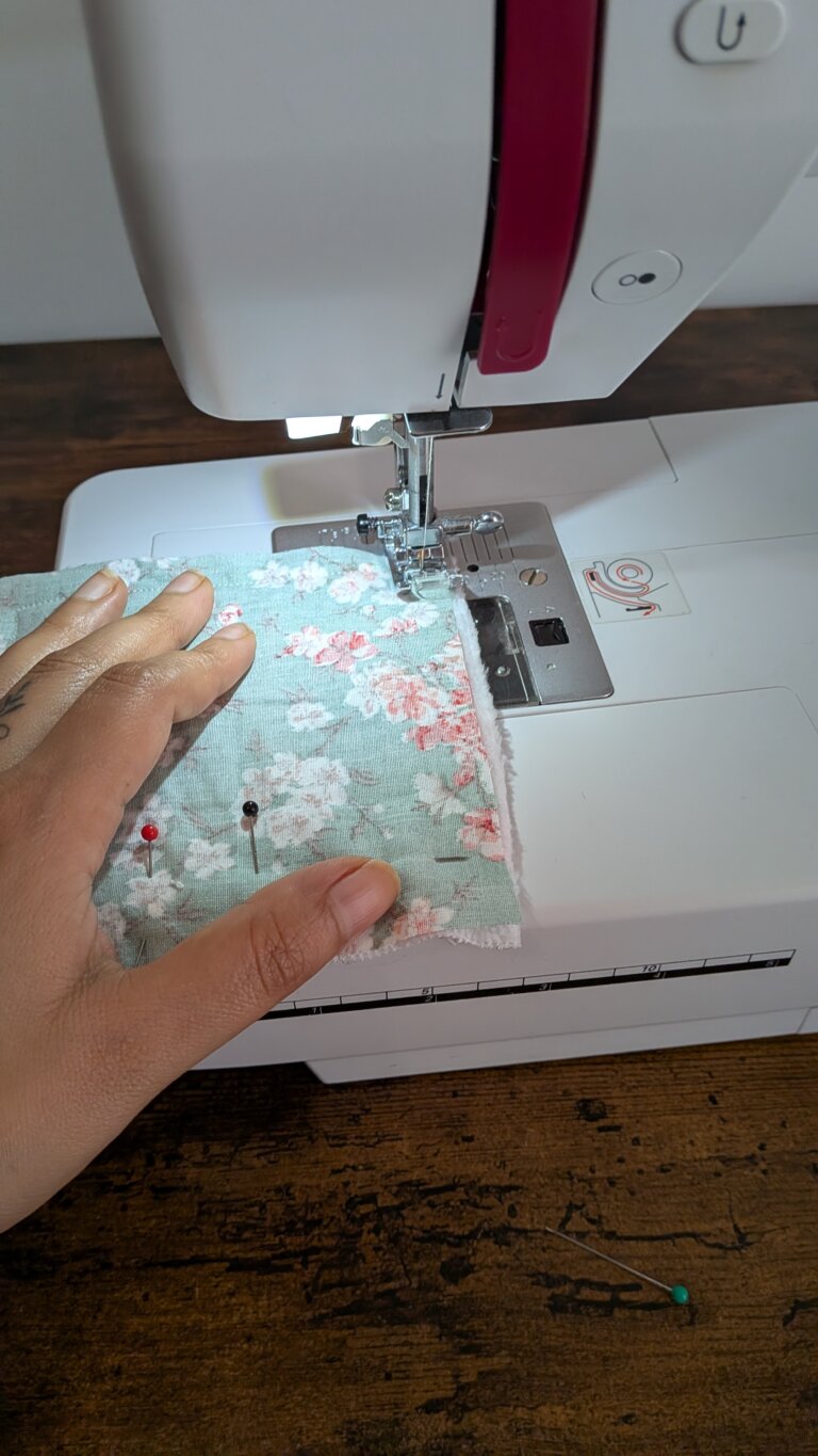 DIY Couture Facile : Cousez Vos Propres Cotons Démaquillants Lavables en Bambou Éponge, saruimagine, coton démaquillant lavable cousu main posé sur une table en bois, lingettes démaquillantes réutilisables en bambou éponge et tissu coloré, matériel de couture avec ciseaux épingles et chutes de tissu pour fabriquer des cotons lavables, étapes de couture d’un coton démaquillant carré en bambou éponge, couture facile pour débutants avec machine à coudre et lingettes lavables, pile de cotons démaquillants lavables pliés dans une panière en osier, détail d’un coton démaquillant lavable 10x10 cm avec surpiqûre, tissus colorés et éponge bambou utilisés pour un projet couture zéro déchet, coffret cadeau écologique avec cotons démaquillants lavables et savon solide, lingettes démaquillantes réutilisables séchant à l’air libre sur un fil, détail d’un tissu bambou éponge blanc doux pour couture zéro déchet, projet couture durable et écoresponsable pour fabriquer des cotons démaquillants lavables, lingettes démaquillantes lavables pliées à côté d’un flacon de lotion naturelle, idée cadeau fait main et écologique avec cotons démaquillants lavables cousus maison, coton démaquillant lavable carré avec face en tissu imprimé et face en bambou éponge.